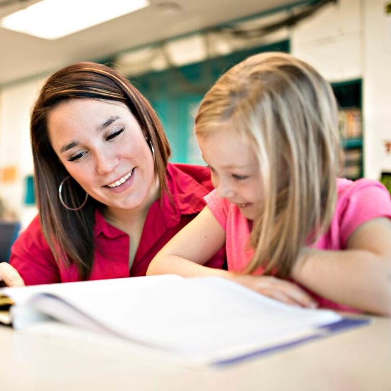 Miracle math coach and child looking at a book.